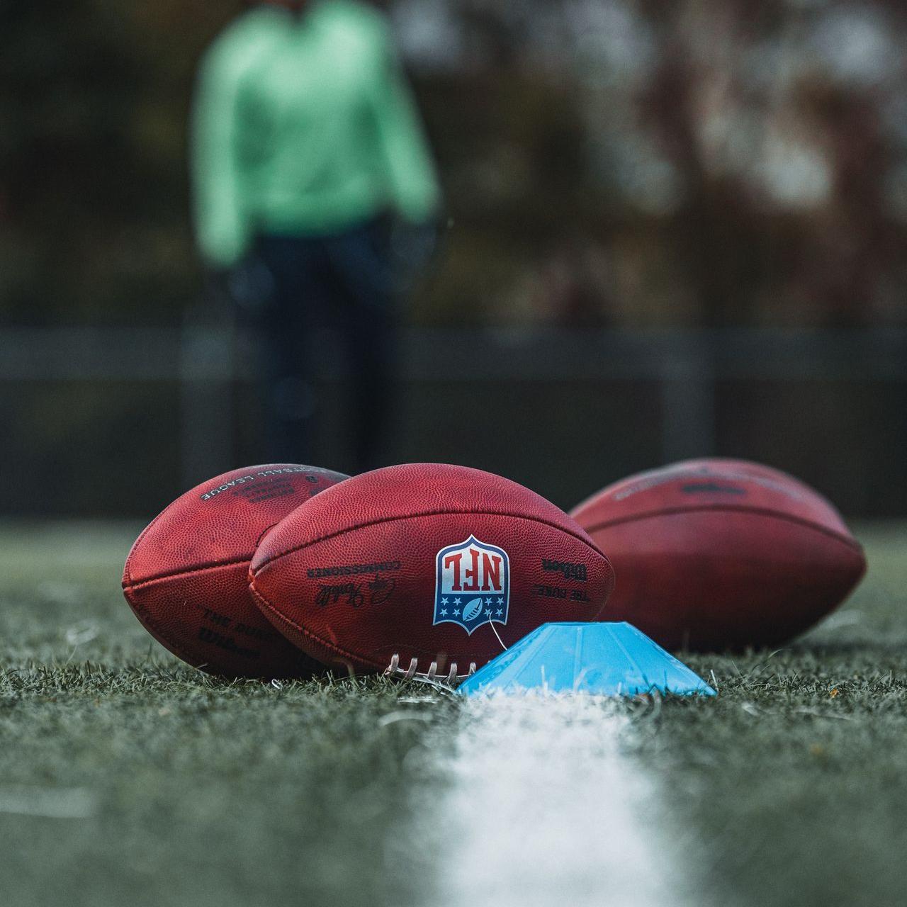 Ballon de football américain au sol à coté d'un plot